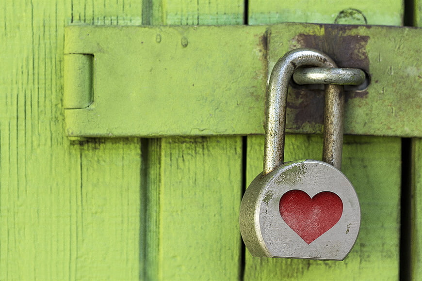 Weathered Padlock With Red Heart On Green Wooden Gate