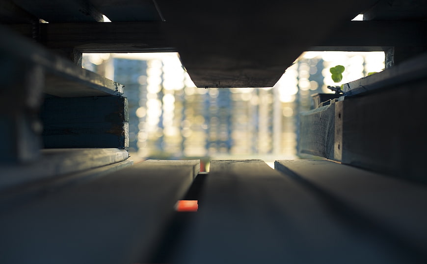 Low angle view through wooden pallet slats with bokeh background