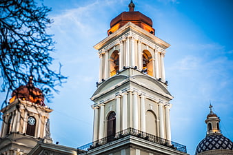 Low angle view of illuminated church bell towers at dusk