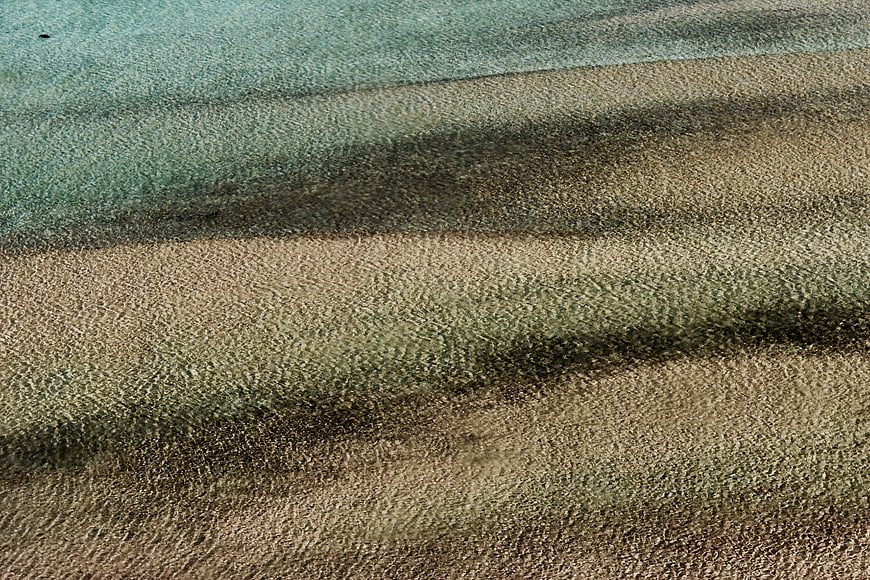 Aerial view of turquoise water and sandy beach texture