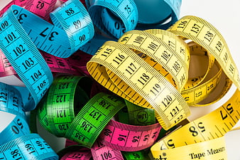 Colorful measuring tapes coiled on white background