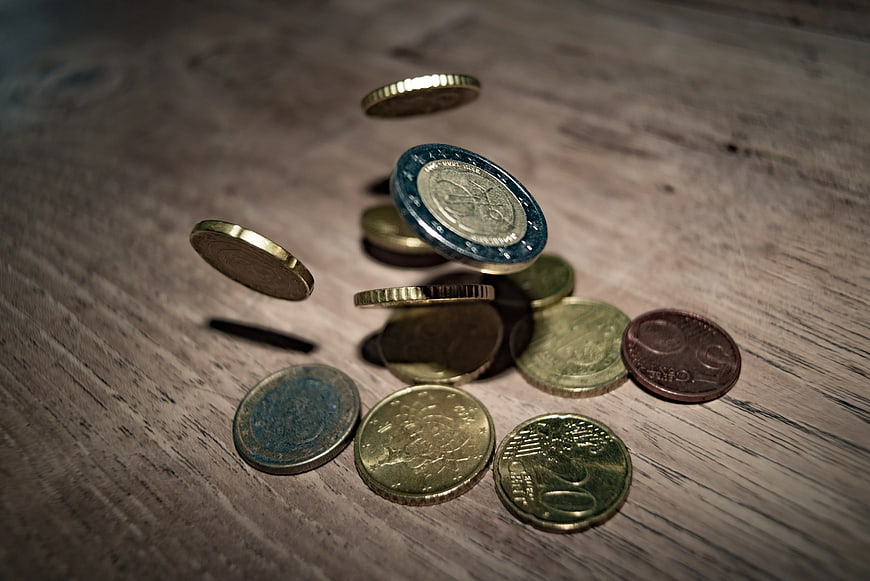 Euro Coins Falling on Wooden Table Surface