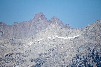 Rugged Rocky Mountain Peaks with Snow Patches Under Blue Sky