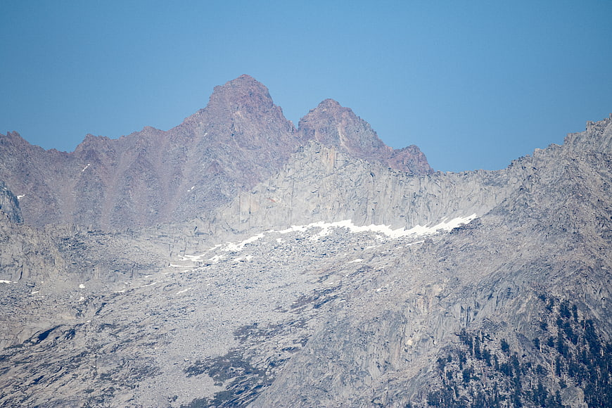 Rugged Rocky Mountain Peaks with Snow Patches Under Blue Sky