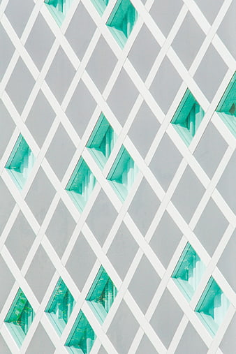 Modern building facade with geometric diamond pattern and teal windows