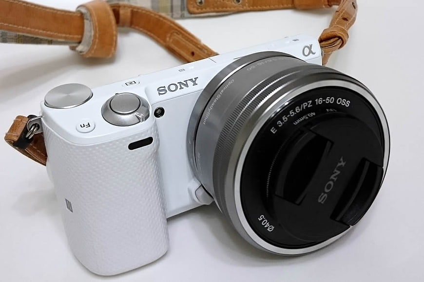 White Sony Alpha Camera with Leather Strap on White Background