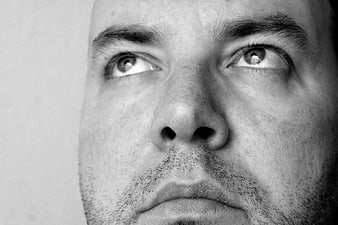 Black and white close-up portrait of a man looking up