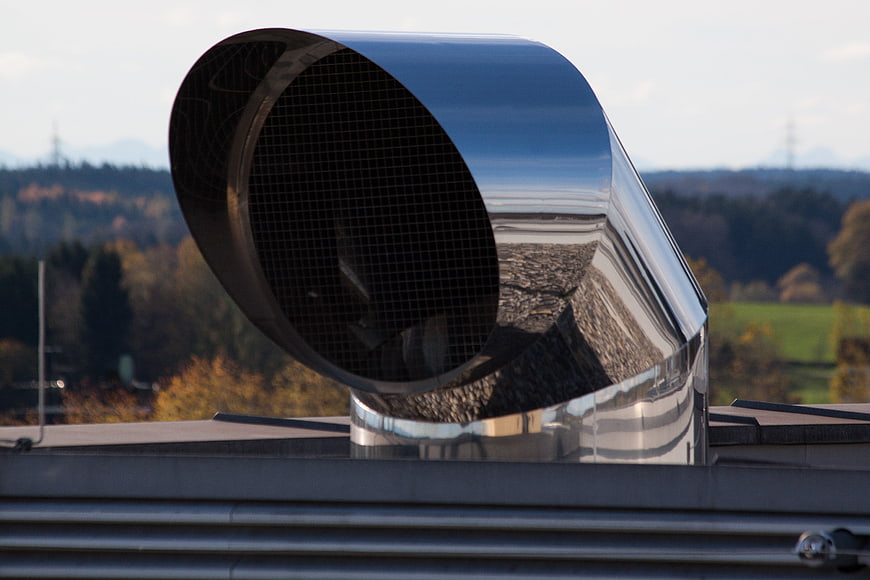 Stainless Steel Ventilation Duct On Rooftop With Autumn Landscape Background