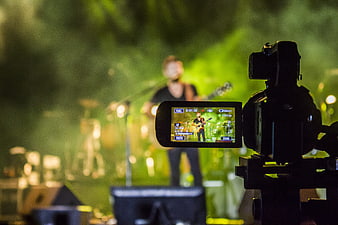 Professional Video Camera Filming Live Musician On Stage