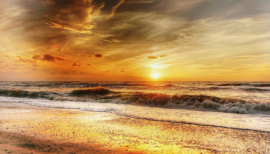 Dramatic Golden Sunset Over Ocean Waves on Sandy Beach