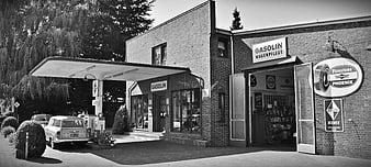 Vintage black and white photo of a retro gas station and car repair shop