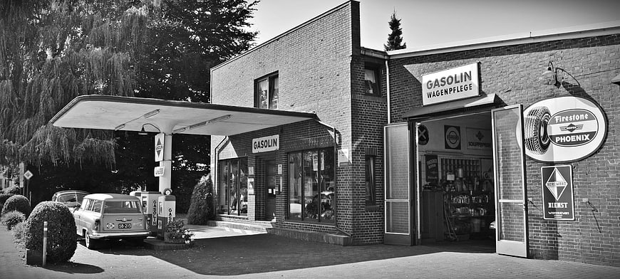 Vintage black and white photo of a retro gas station and car repair shop