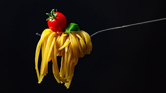 Spaghetti with Cherry Tomato on Fork Against Black Background