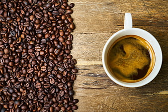 Top View of Coffee Cup and Roasted Beans on Wooden Table