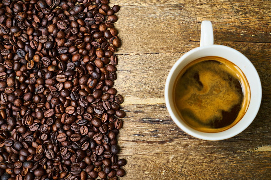 Top View of Coffee Cup and Roasted Beans on Wooden Table