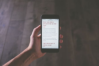 Hand holding smartphone displaying mobile optimization article