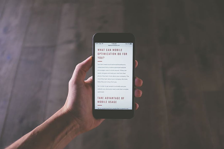 Hand holding smartphone displaying mobile optimization article
