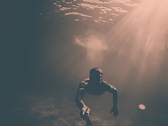 Underwater Man Swimming with Sun Rays