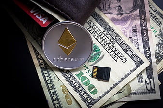 Ethereum coin on US dollar bills with SD card and Visa card