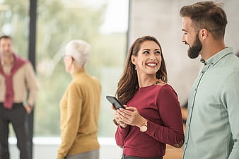 Happy young couple talking in modern office with seniors