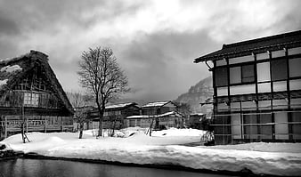 Black and white winter village with traditional thatched roof houses