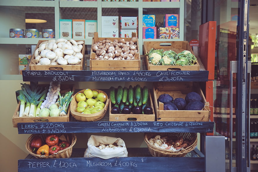 Fresh organic vegetables displayed in wooden crates at a market shop