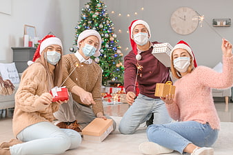 Friends celebrating Christmas with masks and sparklers