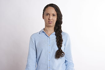 Portrait of confused woman with braid looking at camera
