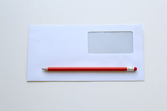 White Window Envelope With Red Pencil On White Background