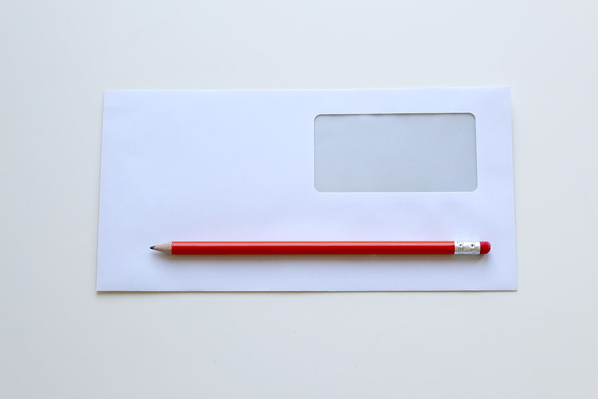 White Window Envelope With Red Pencil On White Background