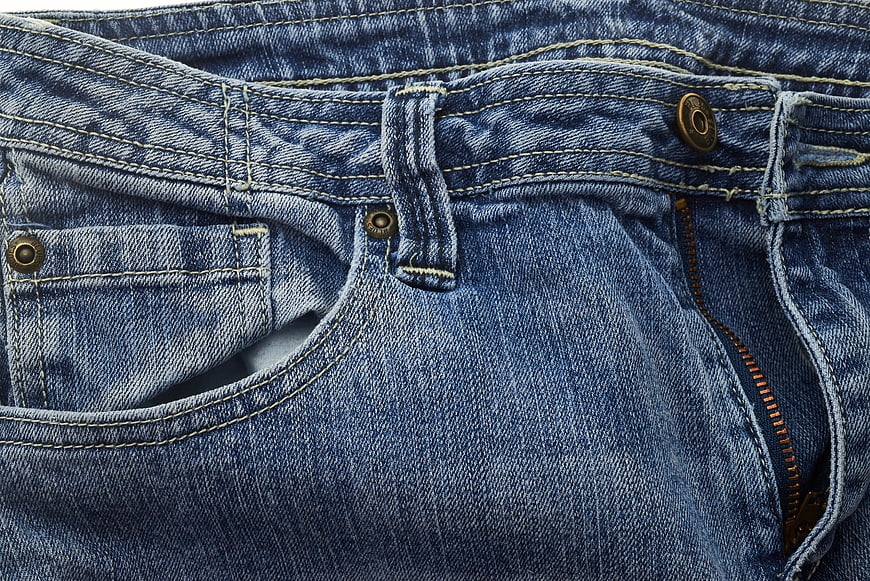 Close-up of blue denim jeans texture with pocket and zipper