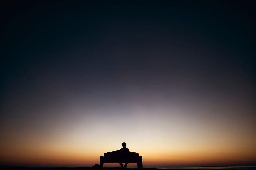 Silhouette of Man Sitting on Bench at Sunset