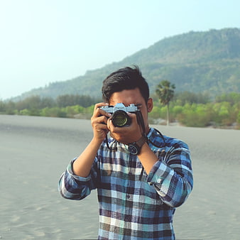 Man Taking Photo with Vintage Camera on Beach
