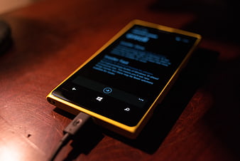 Yellow Windows Smartphone Charging on Wooden Table