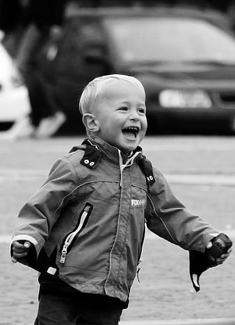 Laughing Toddler Boy in Jacket on Street