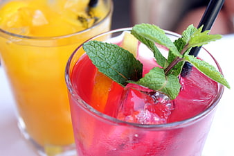 Refreshing Red and Orange Fruit Cocktails Garnished With Fresh Mint Leaves
