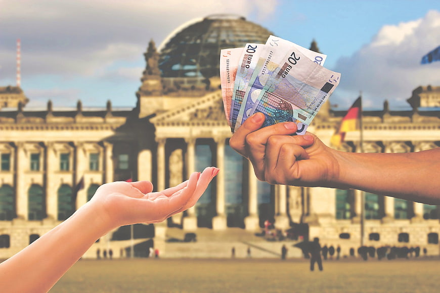 Handing Euro Banknotes In Front Of German Bundestag Building