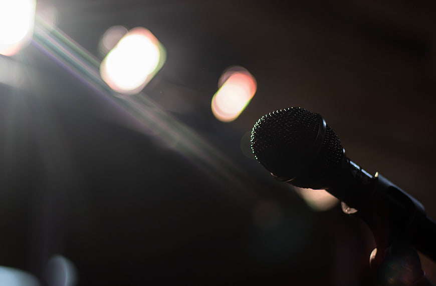 Close-up of microphone on stage with bokeh lights