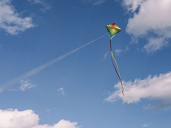 Colorful Rainbow Kite Flying in Blue Sky with Clouds