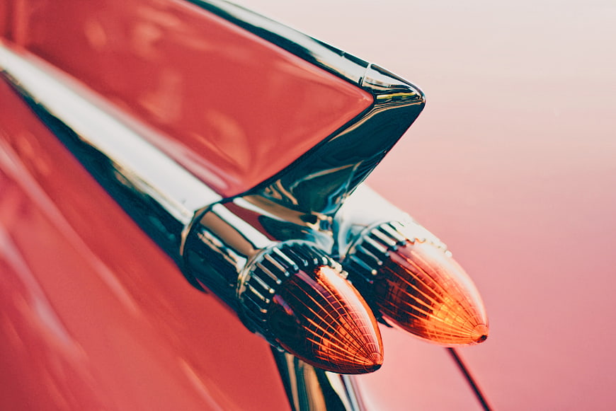 Close-up of vintage red car tail fin and chrome taillight