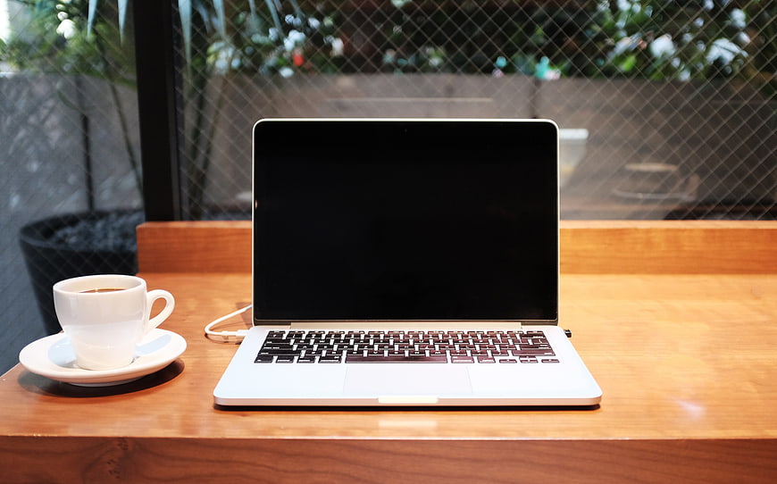 Laptop and Coffee Cup on Wooden Table