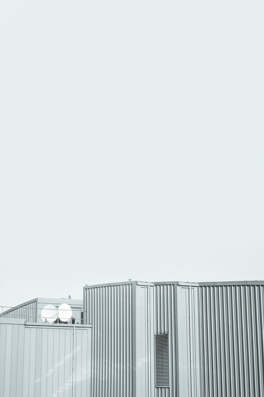 Minimalist industrial architecture with corrugated metal and satellite dishes