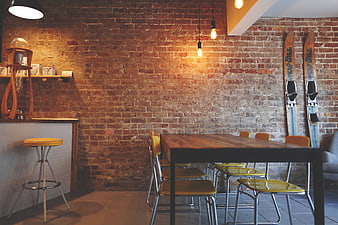 Rustic interior with brick wall, wooden table, and vintage skis