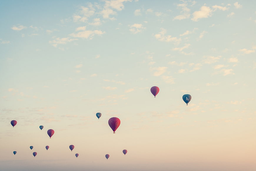 Hot Air Balloons Flying in Pastel Sky at Sunset