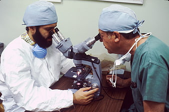 Two doctors examining microscope in medical laboratory