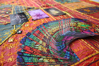 Colorful Stained Glass Tarot Cards Fanned on Red Embroidered Cloth