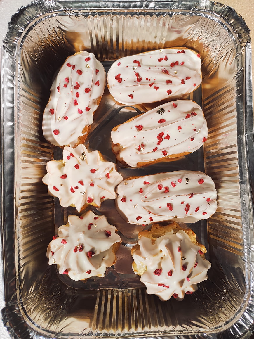 Homemade Eclairs with White Icing in Foil Tray