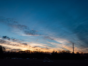 Dramatic Sunset Sky Over Silhouetted Park Landscape