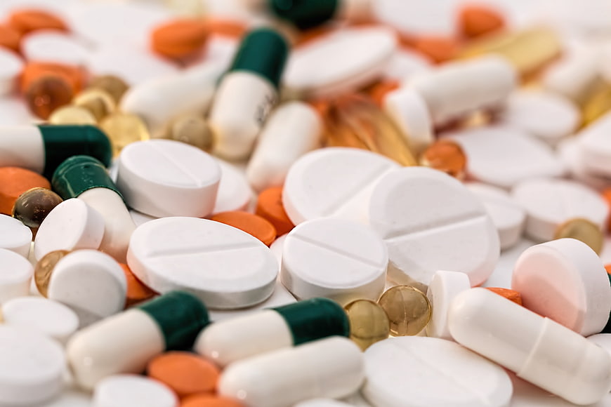 Close-up of assorted pills, capsules, and tablets on white background