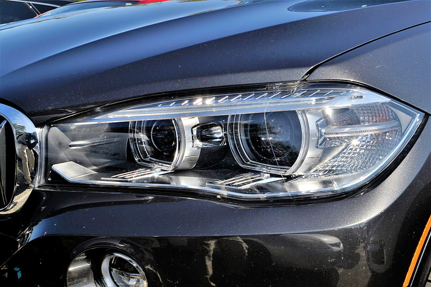 Close-up of a black BMW headlight with chrome details